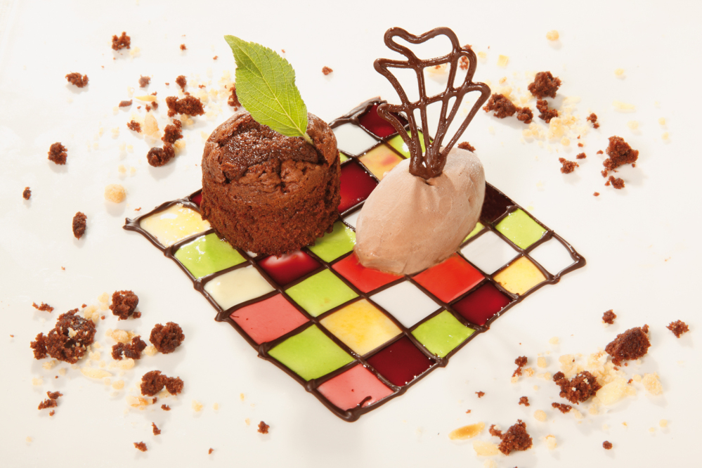Dessert - Schokoladenküchlein mit Karamell-Eis auf Schokoladen-Gitter
