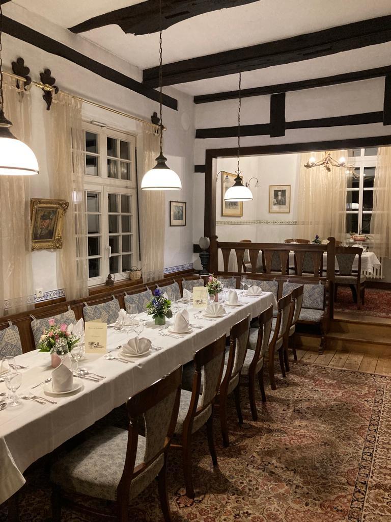 Beste Stube mit langer gedeckter Tafel, Pendelleuchten und Holzbalken